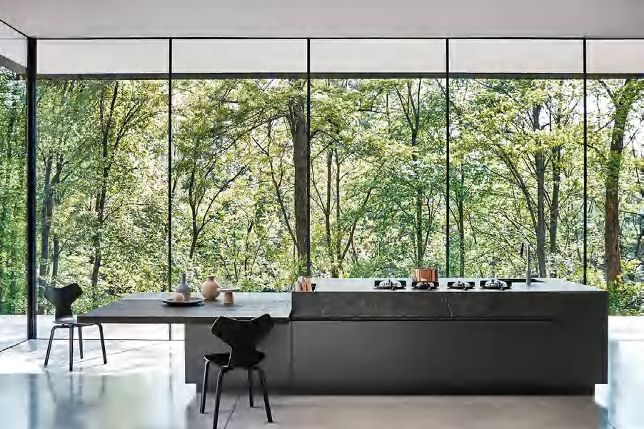 Dark kitchen island facing full-height windows in a residential project