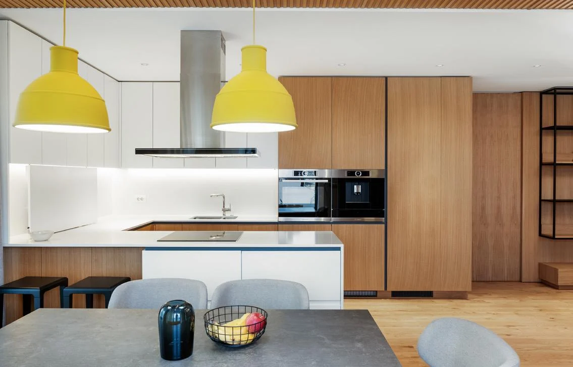 Warm wood veneer kitchen wall with island and dining area