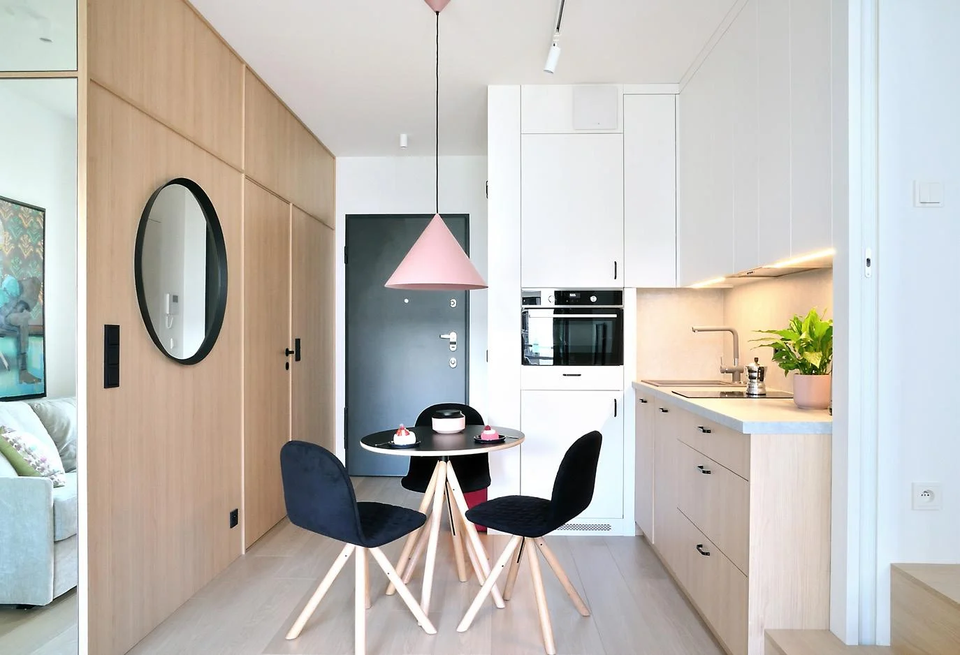 Compact modern kitchen with white cabinetry and dining table