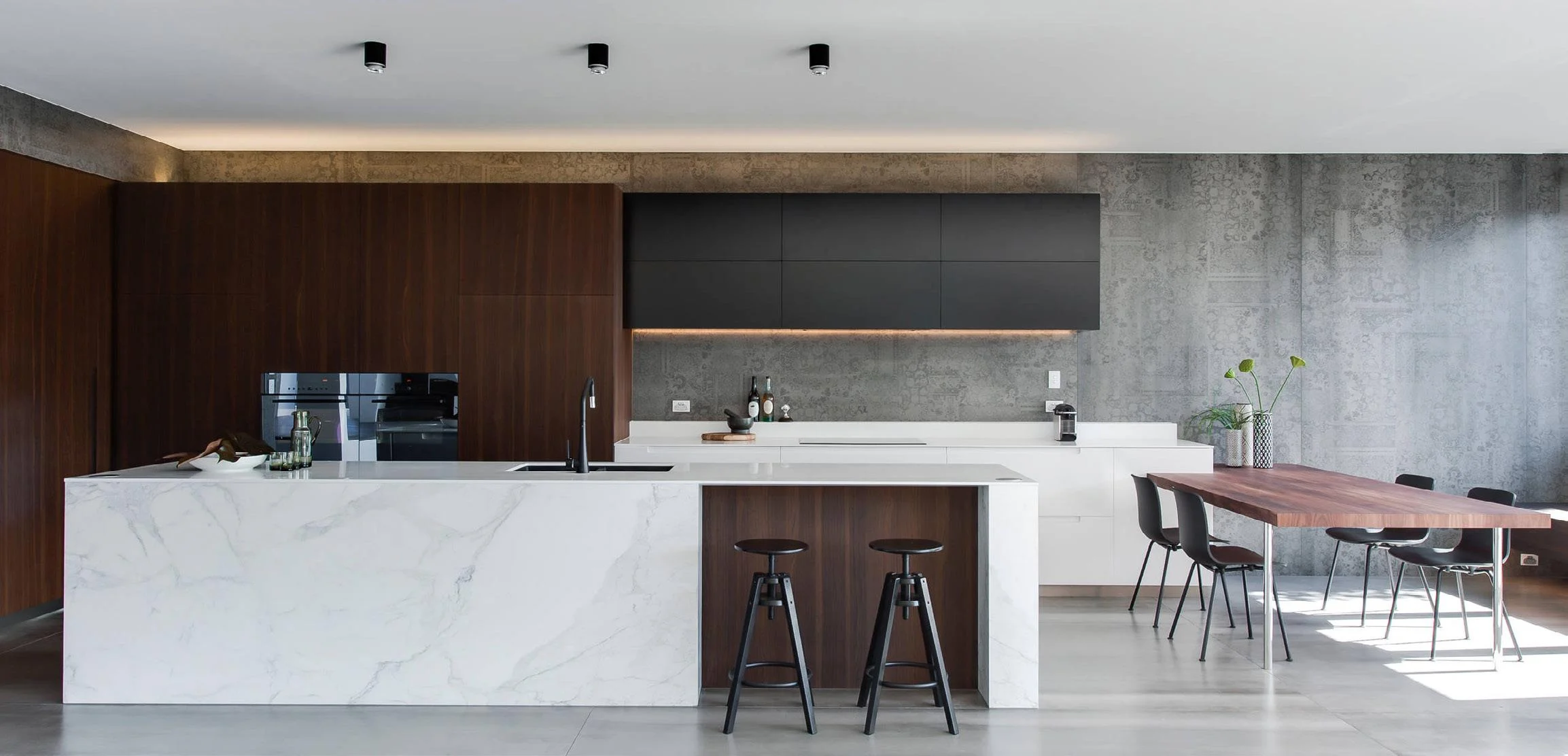 Modern wood and white kitchen with stone island in an open-plan interior