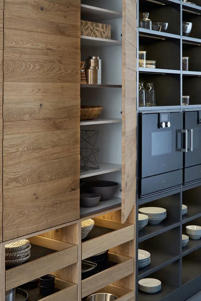 Kitchen tall-unit cabinetry showing shelves, drawers and contrasting finishes